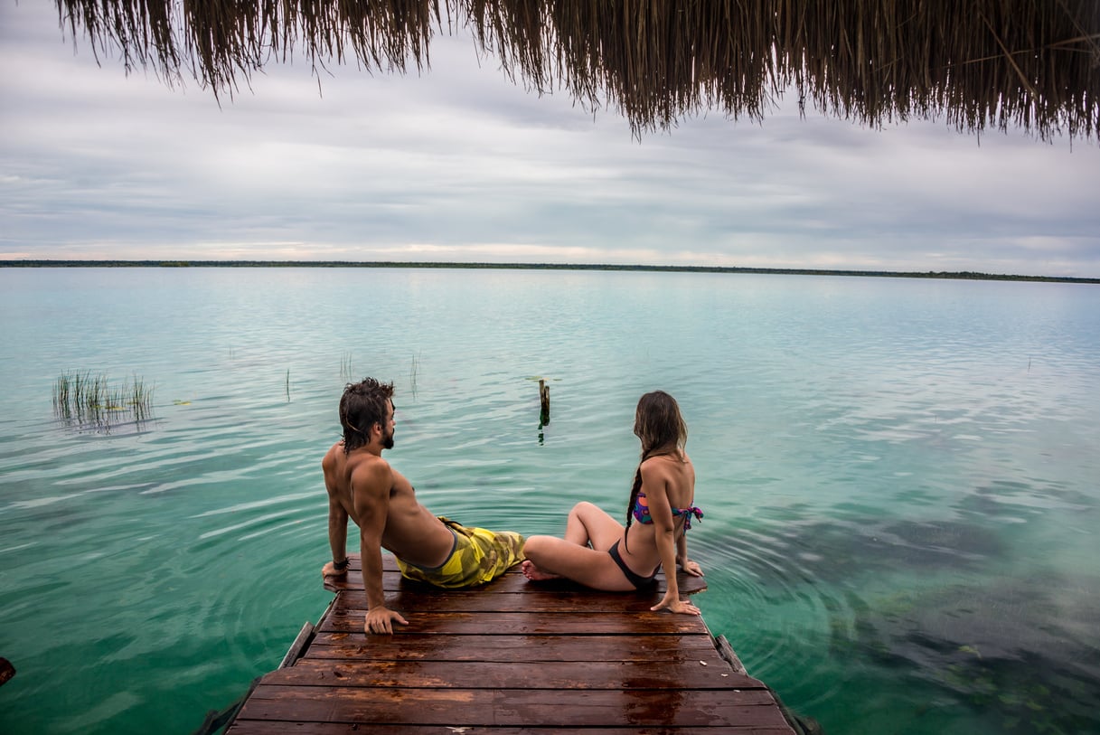 Beautiful couple in love looking at Bacalar lake. Mexico